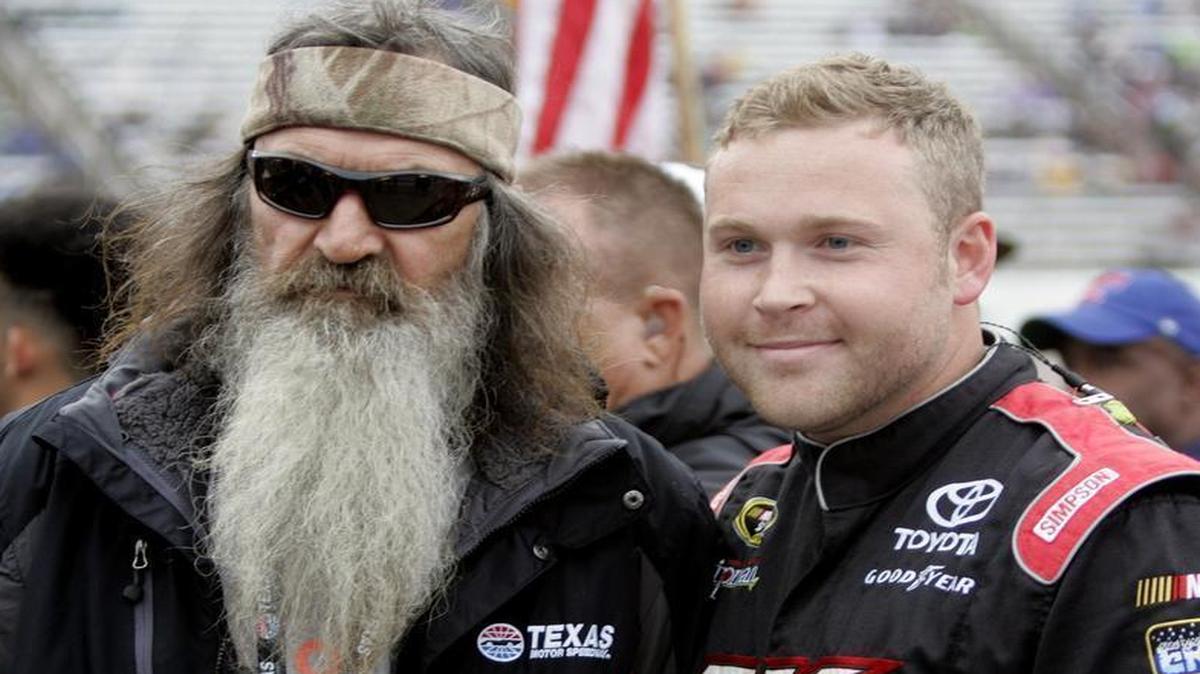 Phil Robertson poses for a photo with Zach Case, crew member for David Ragan, at the Duck Commander 500. Robertson’s pre-race prayer made headlines.