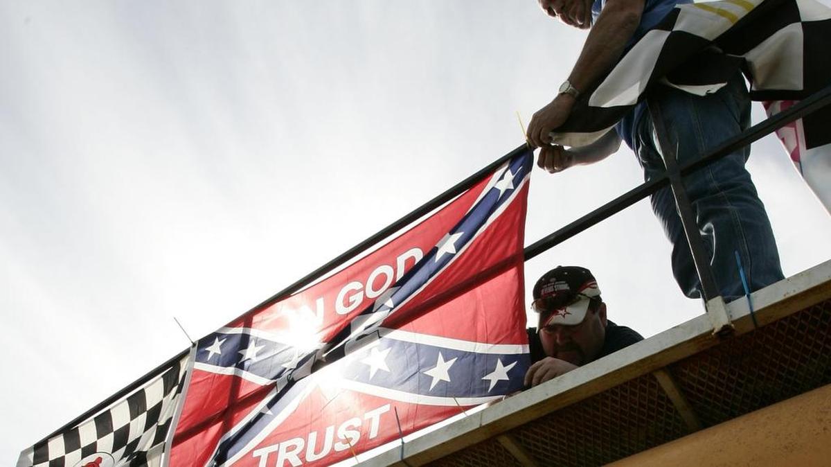 
Fans at a NASCAR race at Texas Motor Speedway hang banners on their vehicle. NASCAR Industry Members asked their fans Thursday to keep Confederate flags from the track. 

