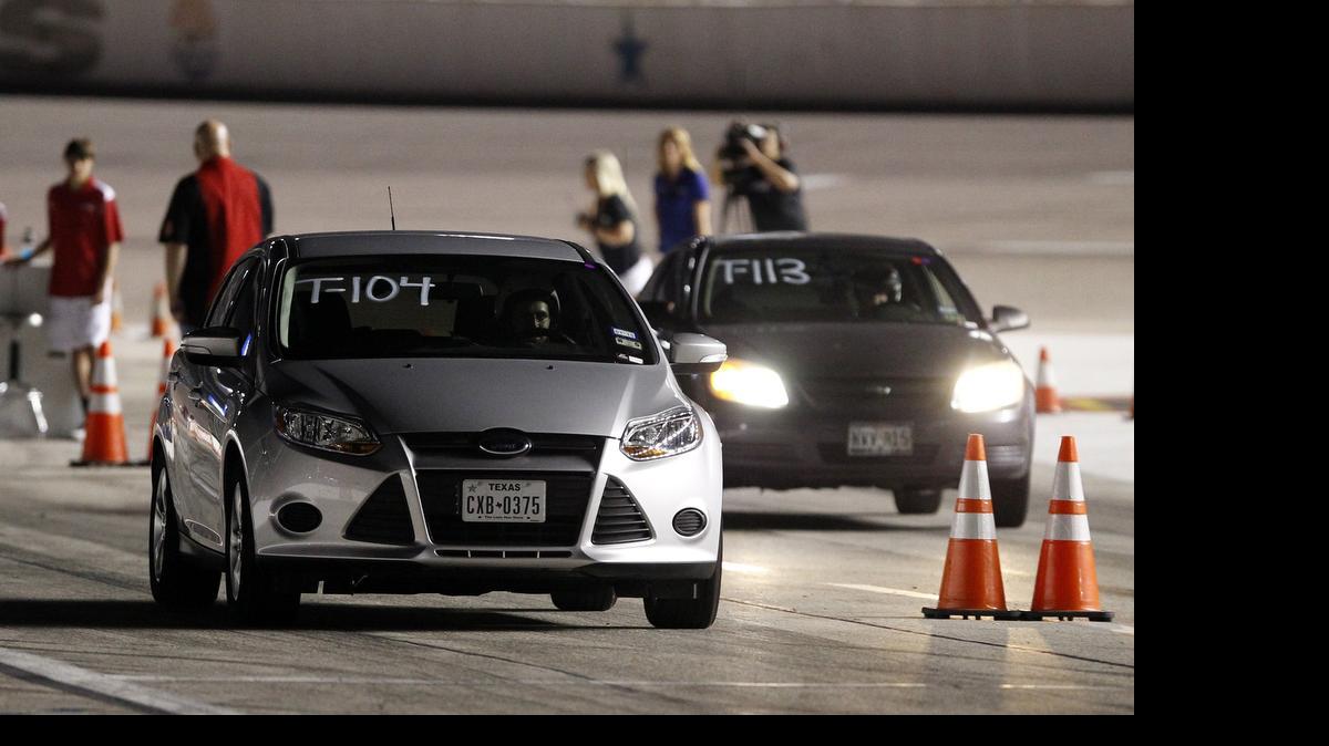 
Cars race down pit road at Texas Motor Speedway during Friday Night Drags.
