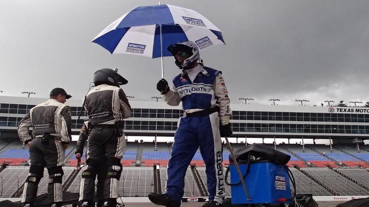 Crews take their equipment back to the garage as it rains at the IndyCar Firestone 600 race at the Texas Motor Speedway, Sunday.