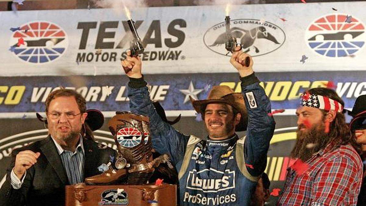 
Jimmie Johnson fires the six-shooters to celebrate winning the Duck Commander 500 at Texas Motor Speedway. He was flanked by Duck Dynasty star Willie Robertson, right, and track president Eddie Gossage. 
