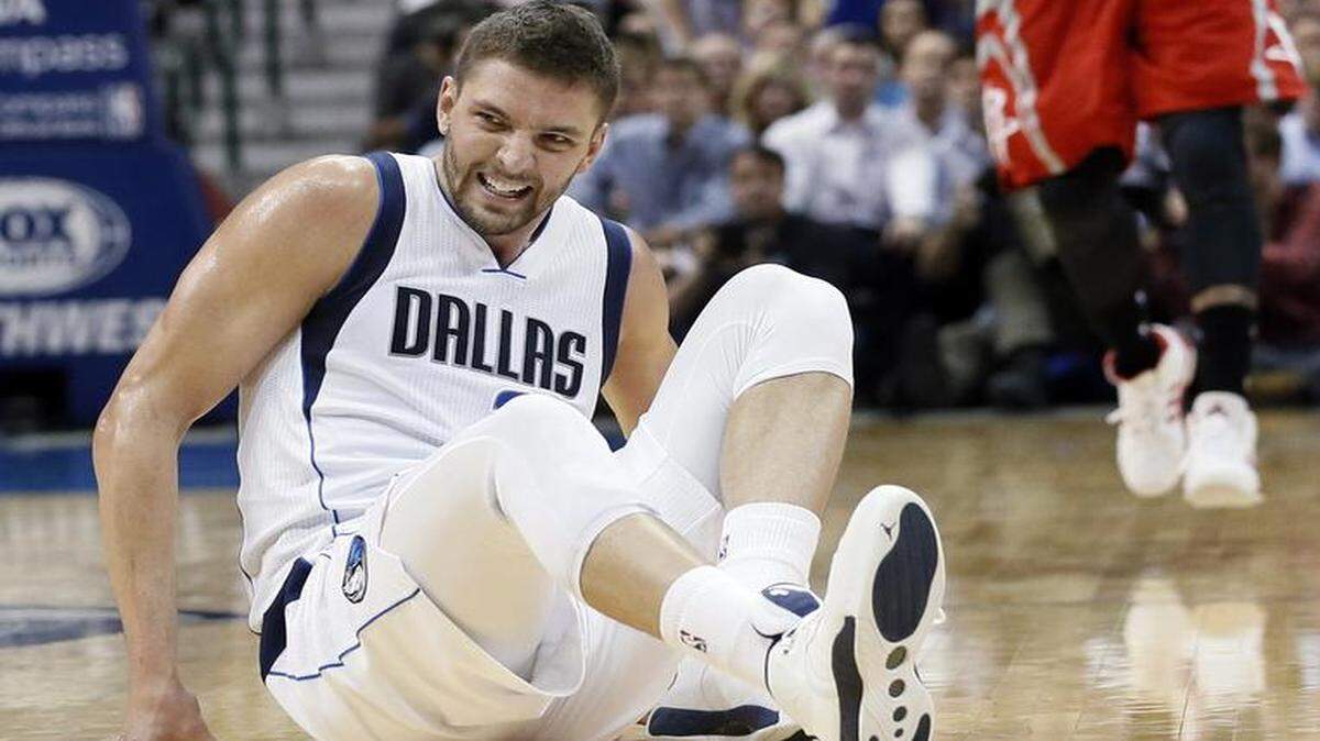 
Mavericks’ Chandler Parsons grimaces as he gets up off the court after a hard fall as Houston Rockets’ Josh Smith (5) calls for the ball during the second half of Game 1 on Thursday.
