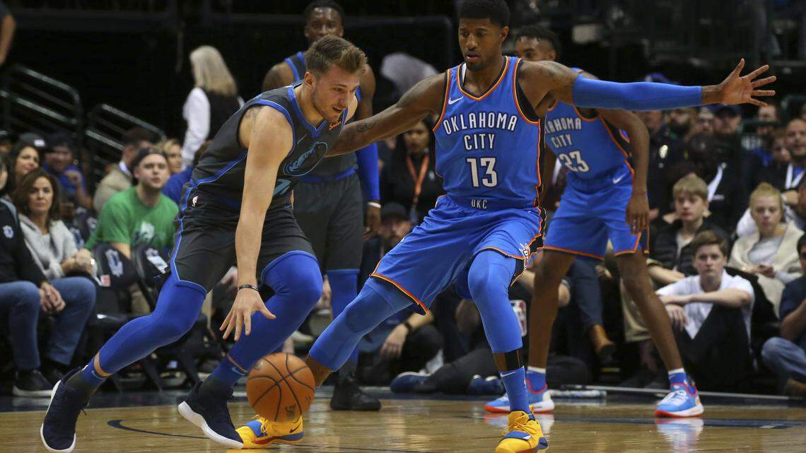 Dallas Mavericks rookie Luka Doncic tries to drive past Oklahoma City Thunder forward Paul George during the first quarter Saturday night in Dallas.
