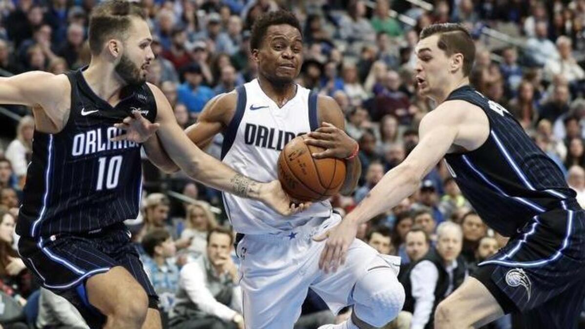 Mavericks guard Yogi Ferrell, middle, splits the defense for Orlando’s Evan Fournier, left, and Mario Hezonja during Tuesday’s Dallas victory. Ferrell had 12 points in the third quarter.