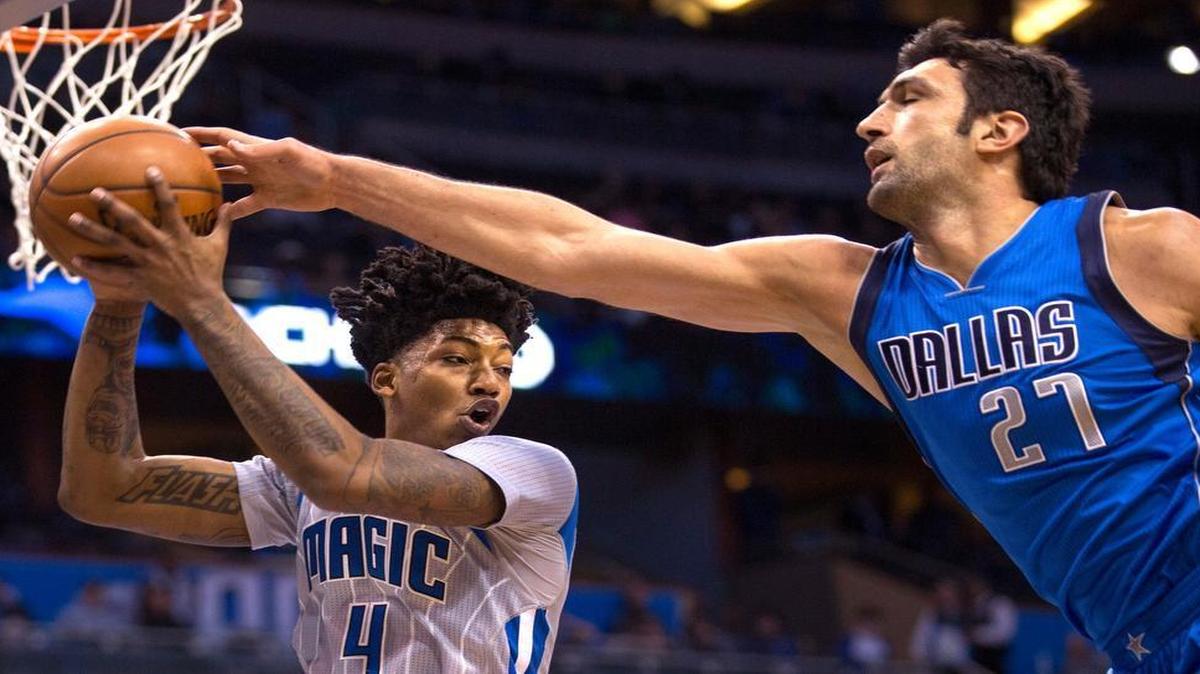 Orlando Magic guard Elfrid Payton pulls a rebound down against Dallas Mavericks center Zaza Pachulia.