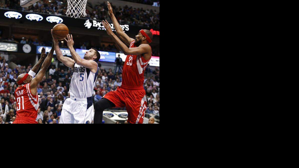 J.J. Barea of the Mavericks puts up a shot between the Rockets’ Jason Terry, left, and Corey Brewer.<252><137>Dallas Mavericks guard J.J. Barea (5) shoots between Houston Rockets guard Jason Terry (31) and Houston Rockets guard Corey Brewer (33) during the first half of a basketball game, Friday, February 20, 2015, at the American Airlines Center, Dallas,Texas. (Special to the Star-Telegram/Jim Cowsert)<252><137>