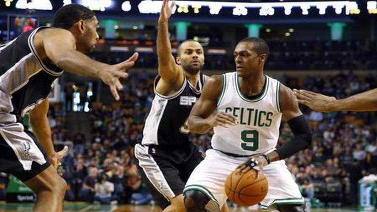 
Boston Celtics guard Rajon Rondo finds himself surrounded by San Antonio Spurs' Tim Duncan, left, Tony Parker and Kawhi Leonard (2) during the first quarter of an NBA basketball game in Boston Sunday, Nov. 30, 2014.
