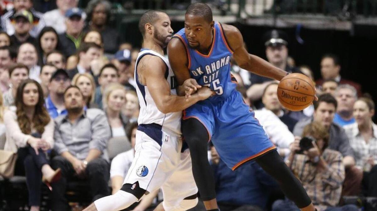 Thunder forward Kevin Durant, right, (35) drives against Mavericks guard Deron Williams (8) during the first half.