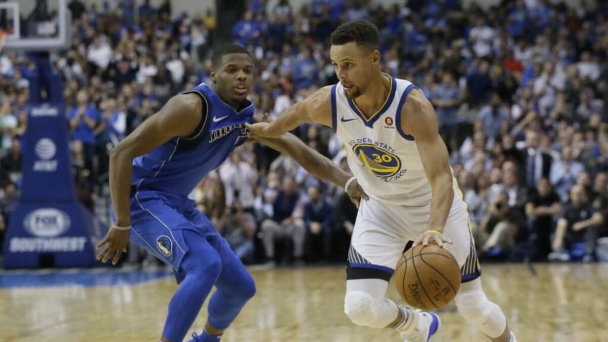 Warriors guard Stephen Curry drives against Dallas Mavericks rookie Dennis Smith Jr., left, in the first half the Mavs’ 133-103 loss Monday night at American Airlines Center.