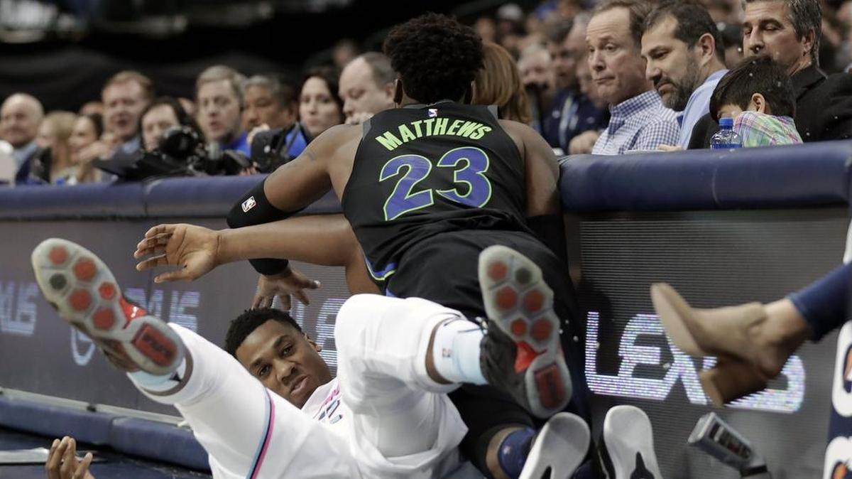 Miami Heat center Hassan Whiteside, left, and Dallas Mavericks forward Wesley Matthews (23) slam into the scorer’s table while chasing after the ball in the first half of Monday in Dallas.