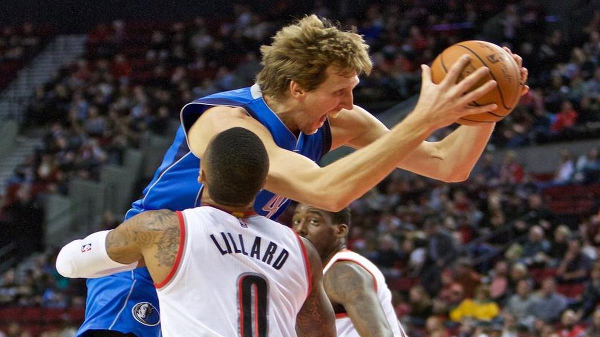 Mavericks forward Dirk Nowitzki, right, is fouled by Portland Trail Blazers guard Damian Lillard, left, during the first half. Nowitzki finished with 28 points, including a tip-in with six seconds left in regulation that sent the game into overtime.