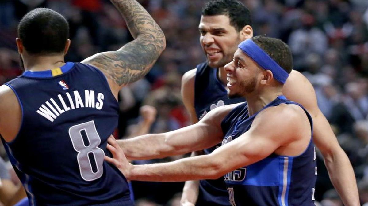 Dallas Mavericks guard Seth Curry, lower right, celebrates with Deron Williams, left, and Salah Mejri after defeating the Chicago Bulls 99-98 in an NBA basketball game, Tuesday, Jan. 17, 2017, in Chicago.