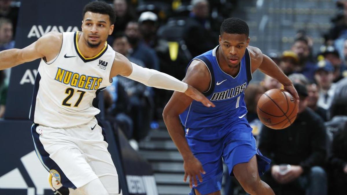 Mavericks rookie Dennis Smith Jr., right, picks up a loose ball as Nuggets guard Jamal Murray defends in the first half of Tuesday’s game in Denver