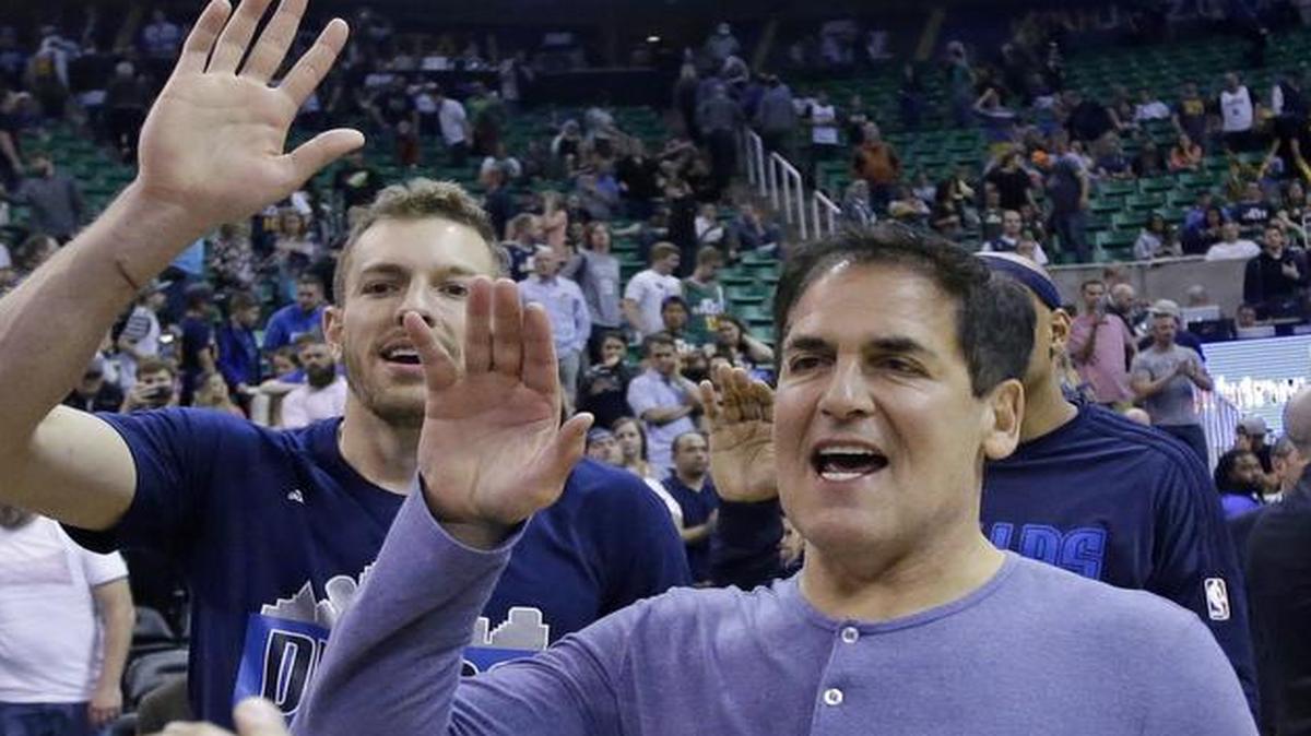 Dallas Mavericks owner Mark Cuban, right, celebrates with Devin Harris, left, and David Lee, rear, after the playoff-clinching win in Utah on Monday.