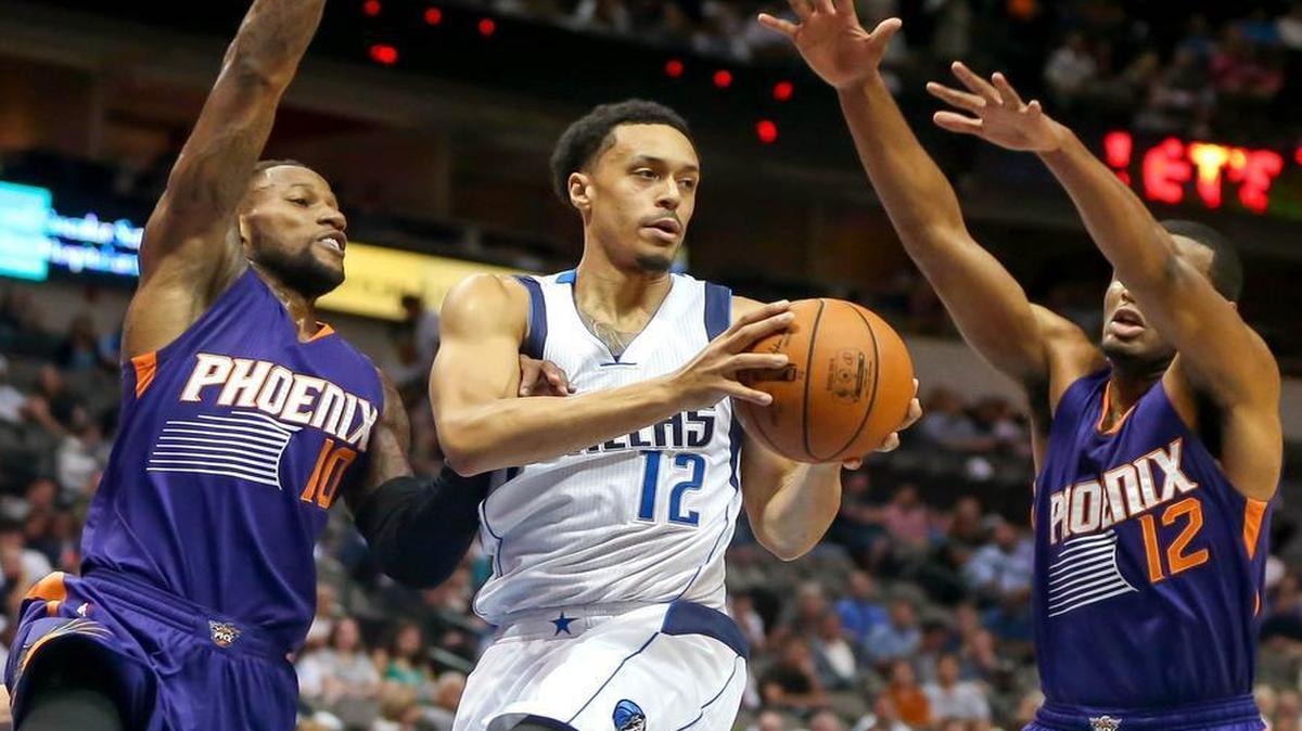 Dallas Mavericks guard John Jenkins drives between the Phoenix Suns’ Sonny Weems, left, and T.J.Warren during the second quarter Wednesday night. Jenkins scored a game-high 22 points.