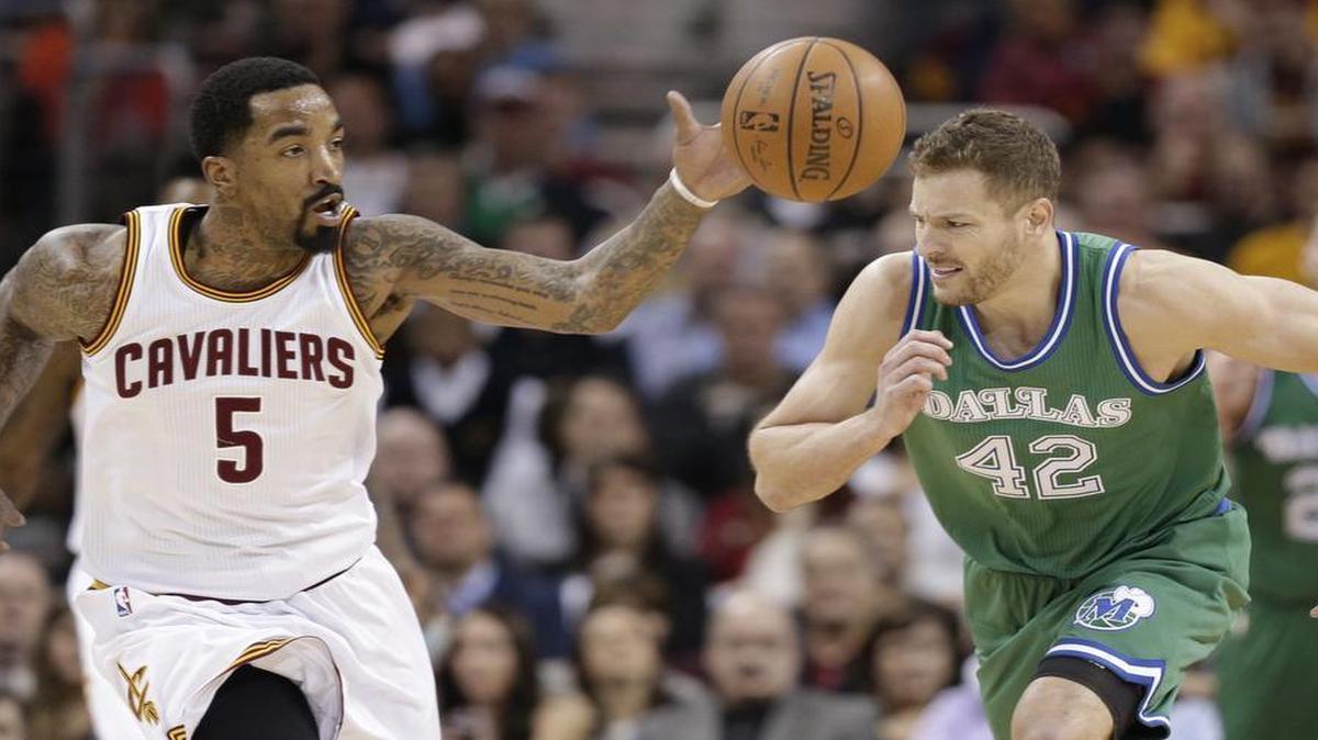 Cleveland Cavaliers gaurd J.R. Smith, left, grabs a loose ball ahead of Dallas Mavericks forward David Lee in the first half.