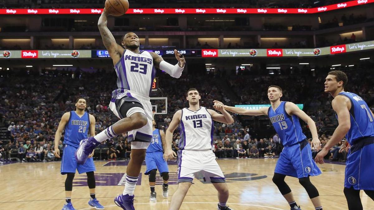At times, young Dallas Mavericks (in blue, from left) AJ Hammons (20), Jarrod Uthoff (19) and Dwight Powell (7) played the role of spectators on plays like this drive by Kings guard Ben McLemore.
