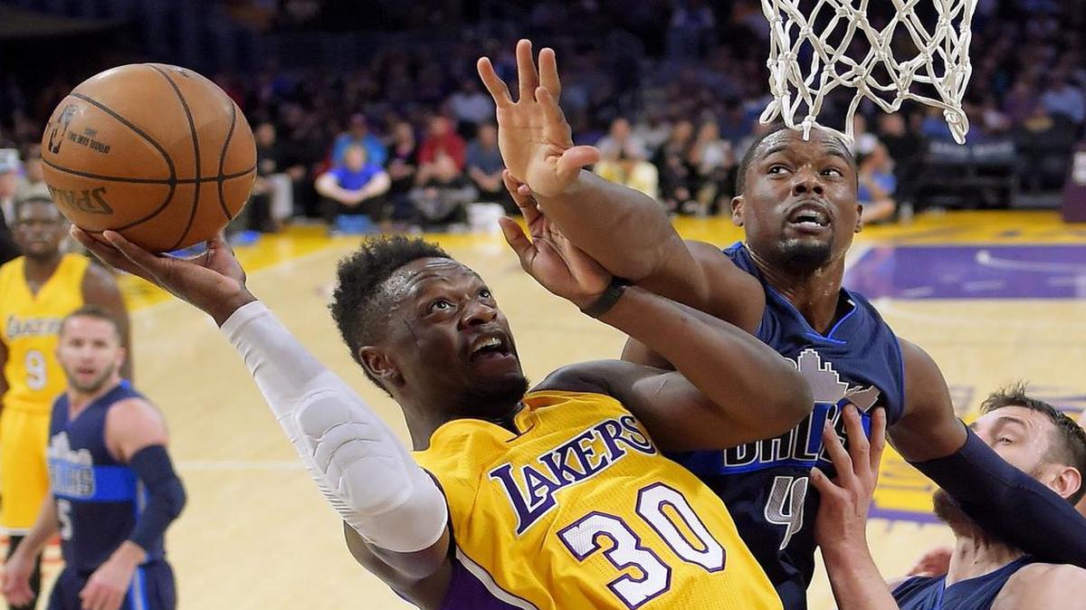 Los Angeles Lakers forward Julius Randle, left, shoots as Dallas Mavericks forward Harrison Barnes defends during the first half of Tuesday’s NBA basketball game in Los Angeles.