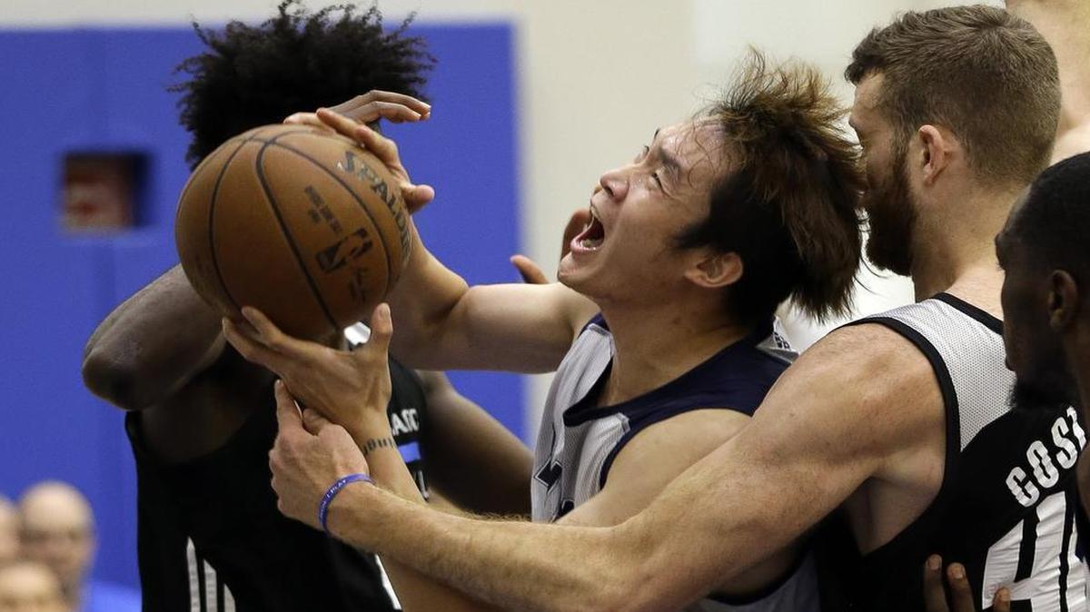 Dallas Mavericks’ Ding Yanyuhang, center, struggles to shoot as he is trapped between Orlando Magic’s Jonathan Isaac, left, and Matt Costello (40) during the first half of an NBA summer league basketball game, Monday, July 3, 2017, in Orlando, Fla.