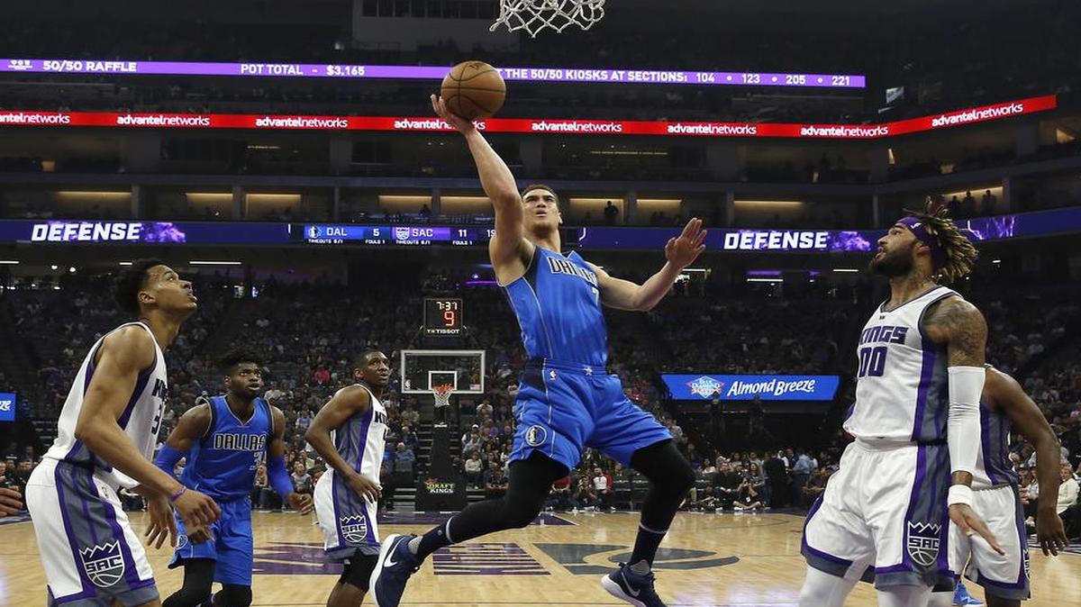 Dallas Mavericks forward Dwight Powell, center, goes to the basket between Sacramento Kings' Skal Labissiere, left, and Willie Cauley-Stein.