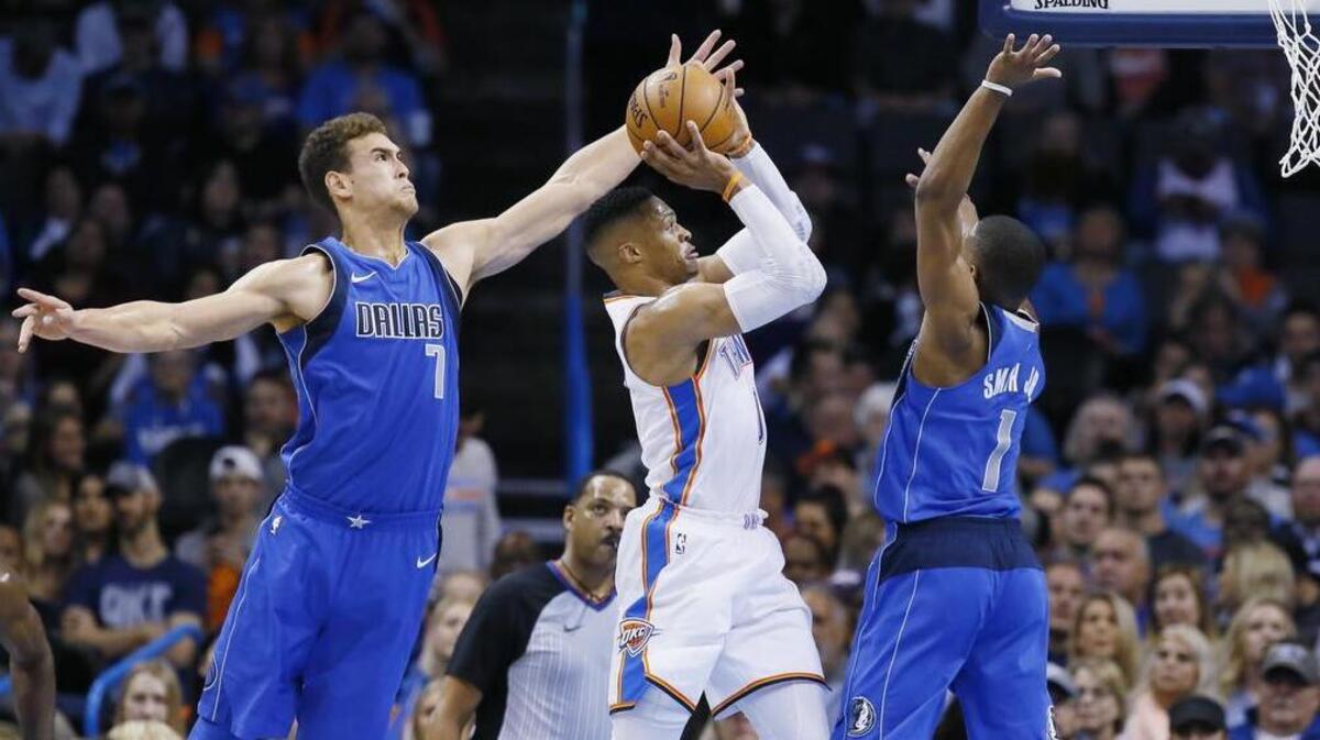 Thunder guard Russell Westbrook shoots between Mavericks forward Dwight Powell (7) and guard Dennis Smith Jr. (1) during Sunday’s game at Oklahoma City.