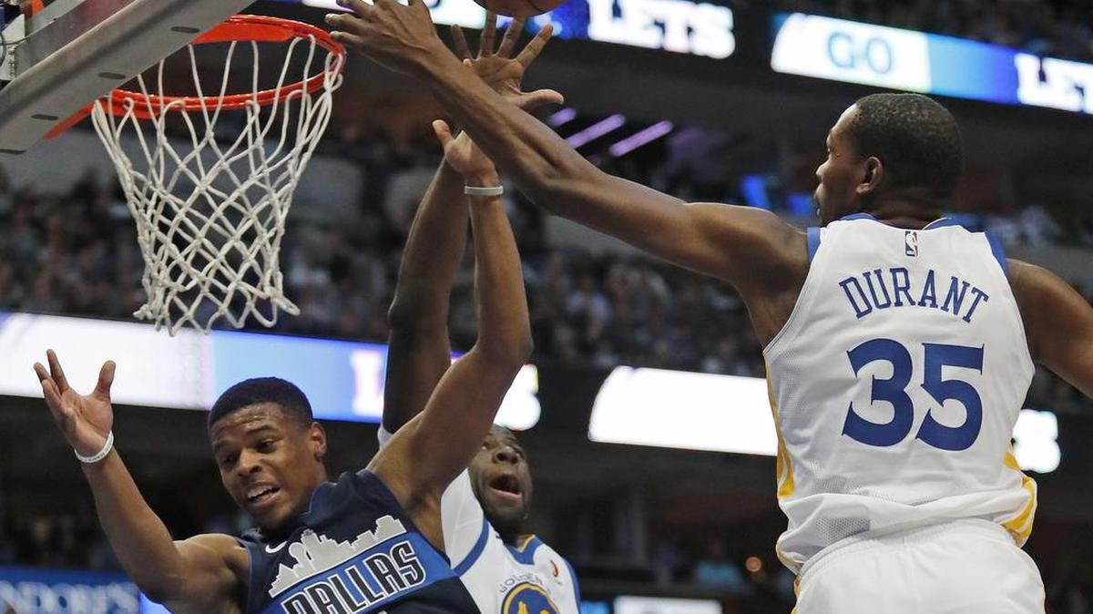 Dallas Mavericks guard Dennis Smith Jr. (1) drives to the basket as Golden State Warriors forward Kevin Durant (35) leaps to defend in the second period as the Golden State Warriors play the Dallas Mavericks in Dallas on Wednesday.