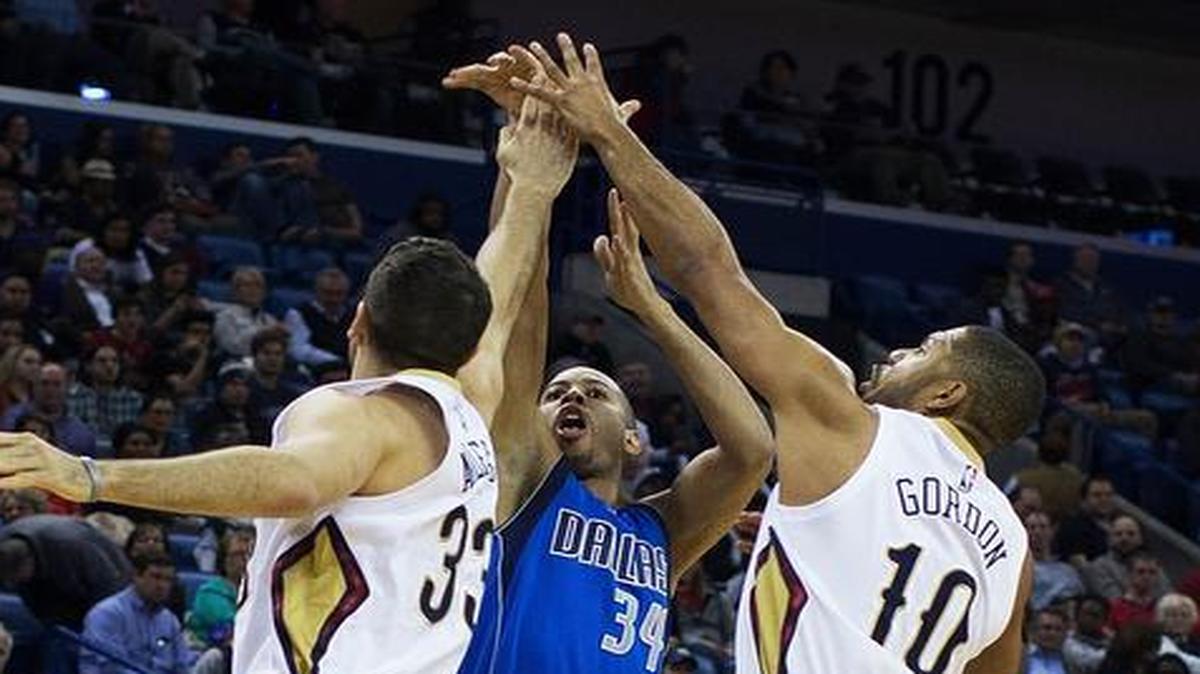 Mavericks guard Devin Harris puts up a shot over Pelicans defenders Ryan Anderson and Eric Gordon.