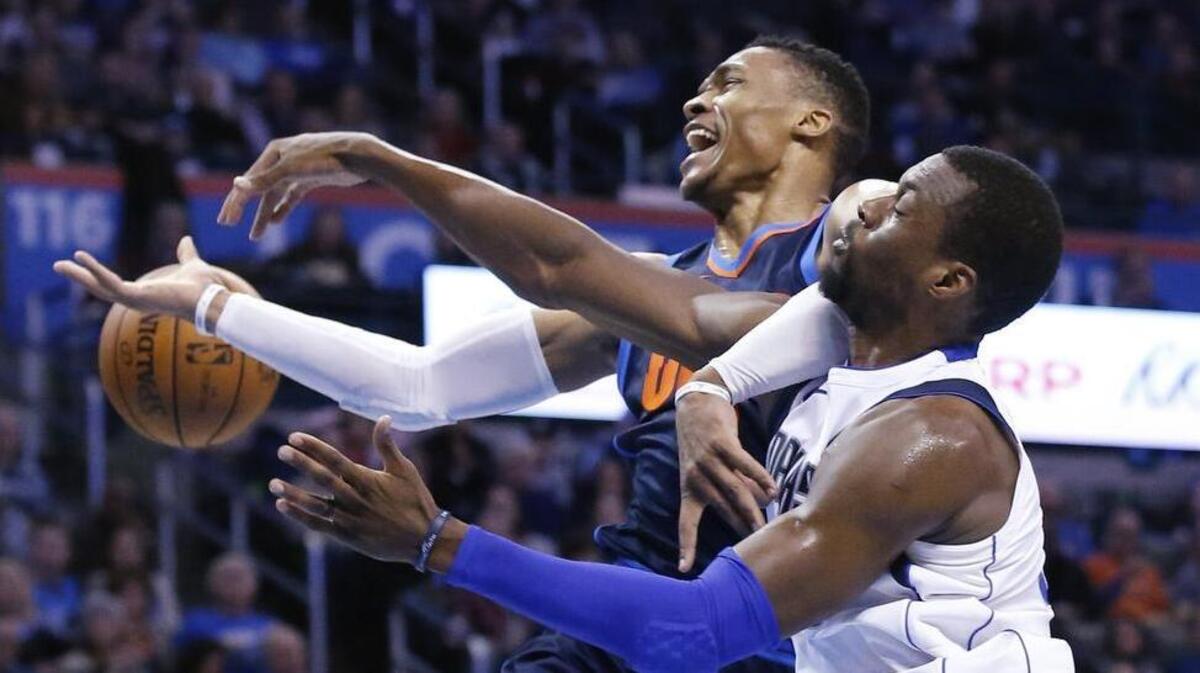 Harrison Barnes, right, knocks the ball away from Thunder guard Russell Westbrook in Sunday’s game. Westbrook finished with his 12th triple-double this season (38 points, 15 rebounds and 11 assists), but Barnes scored 24 points as the Mavs posted their fourth consecutive victory.