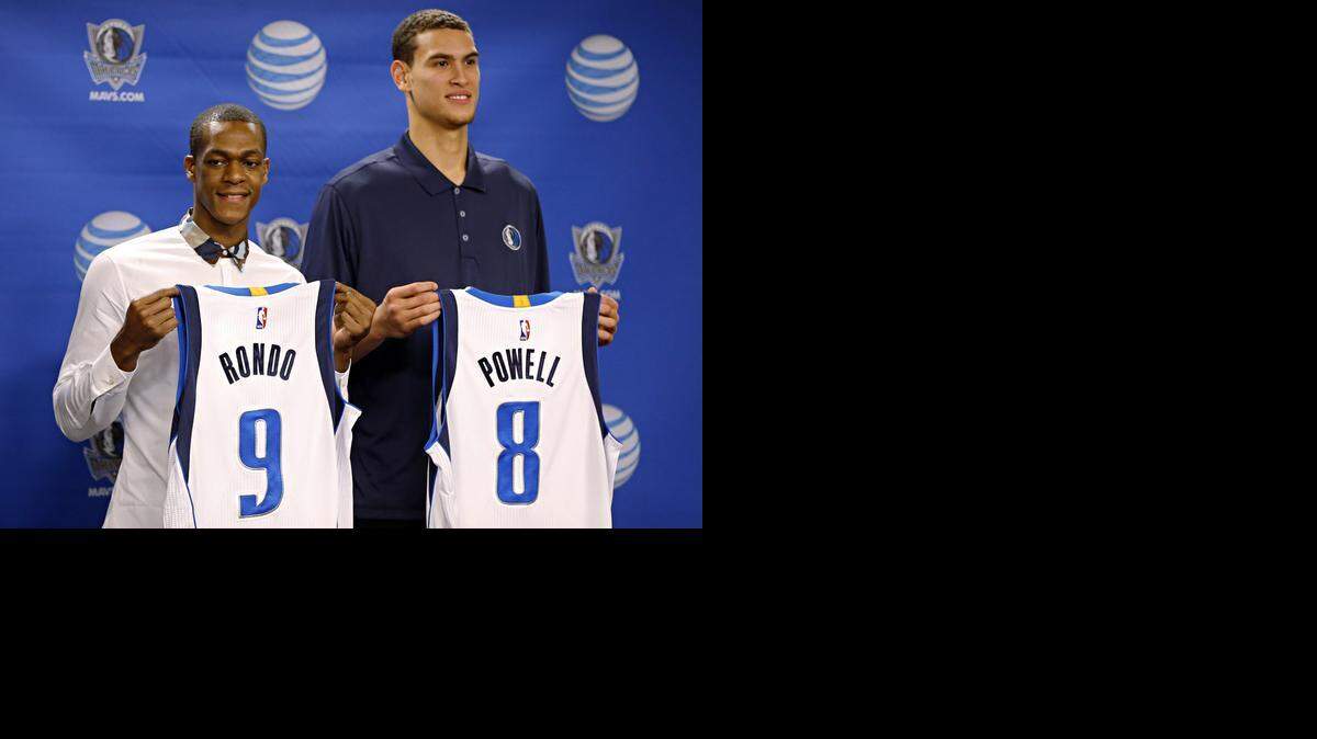 
Rajon Rondo, left, and Dwight Powell hold their new Dallas Mavericks jerseys during a news conference Friday. 
