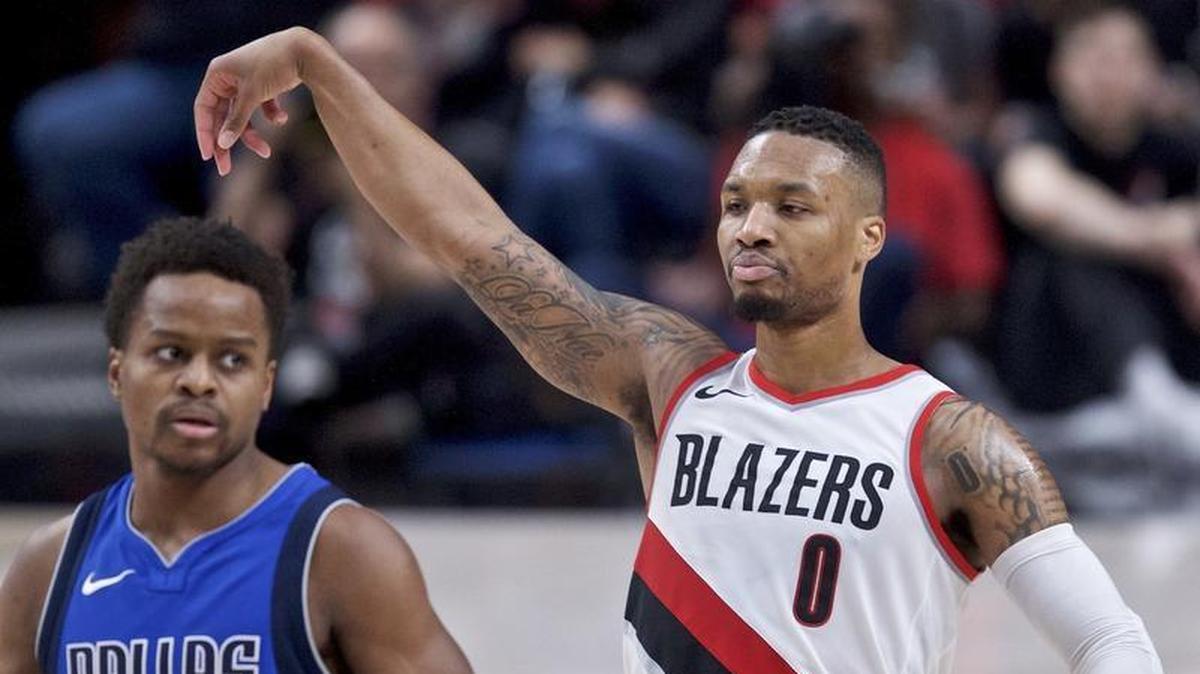 Trail Blazers guard Damian Lillard, right, reacts after making a 3-point basket over Mavericks guard Yogi Ferrell during the second half of Saturday’s game. Lillard had a game-high 31 points in a 117-108 Portland win.