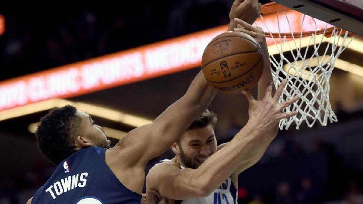 Maxi Kleber, right, who tied a career-high with 16 points, rejects Timberwolves center Karl-Anthony Towns in Sunday’s game. But Towns had 28 points and 12 rebounds as the T’wolves finished with the upper hand.