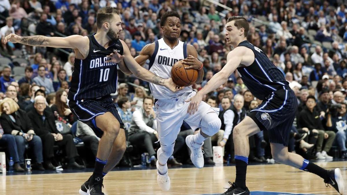Dallas Mavericks guard Yogi Ferrell drives between Orlando Magic forward Evan Fournier and guard Mario Hezonja. Ferrell scored 15 points against Orlando.