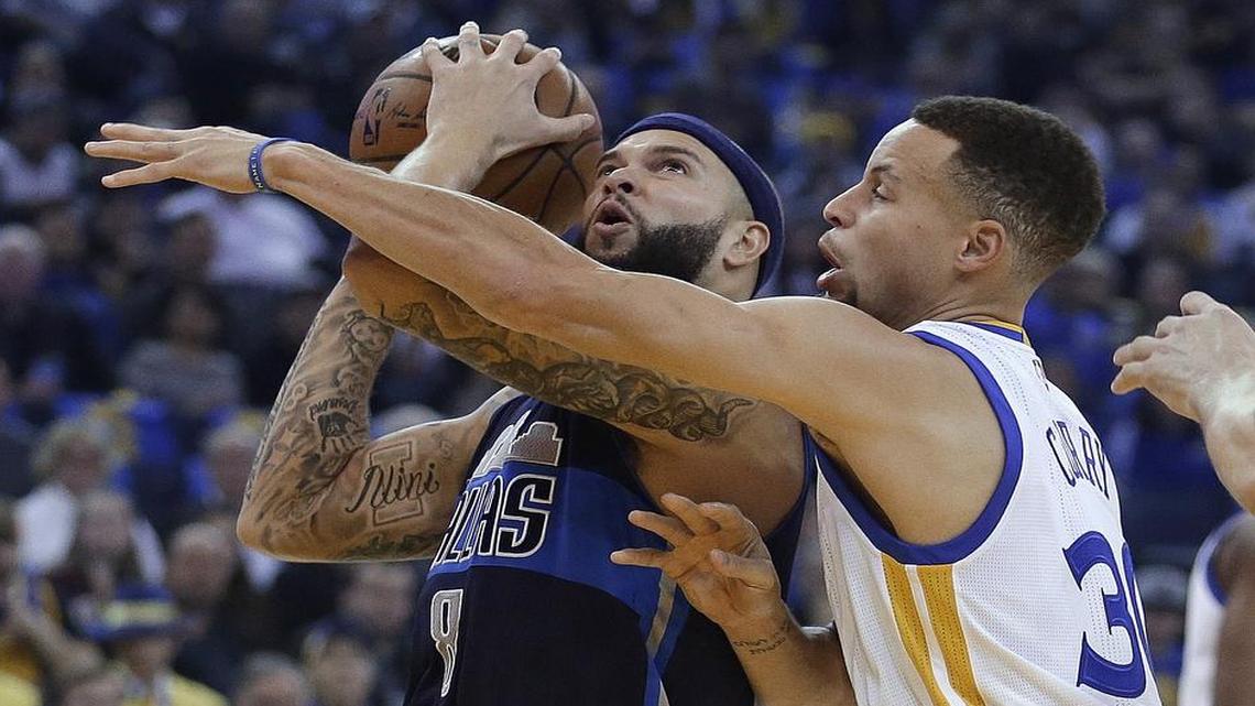 Mavericks guard Deron Williams, left, drives against the defense of Golden State’s Stephen Curry. The Warriors won the game 127-107 despite Curry, the NBA’s leading scorer, getting less than half of his 30.3 point average.