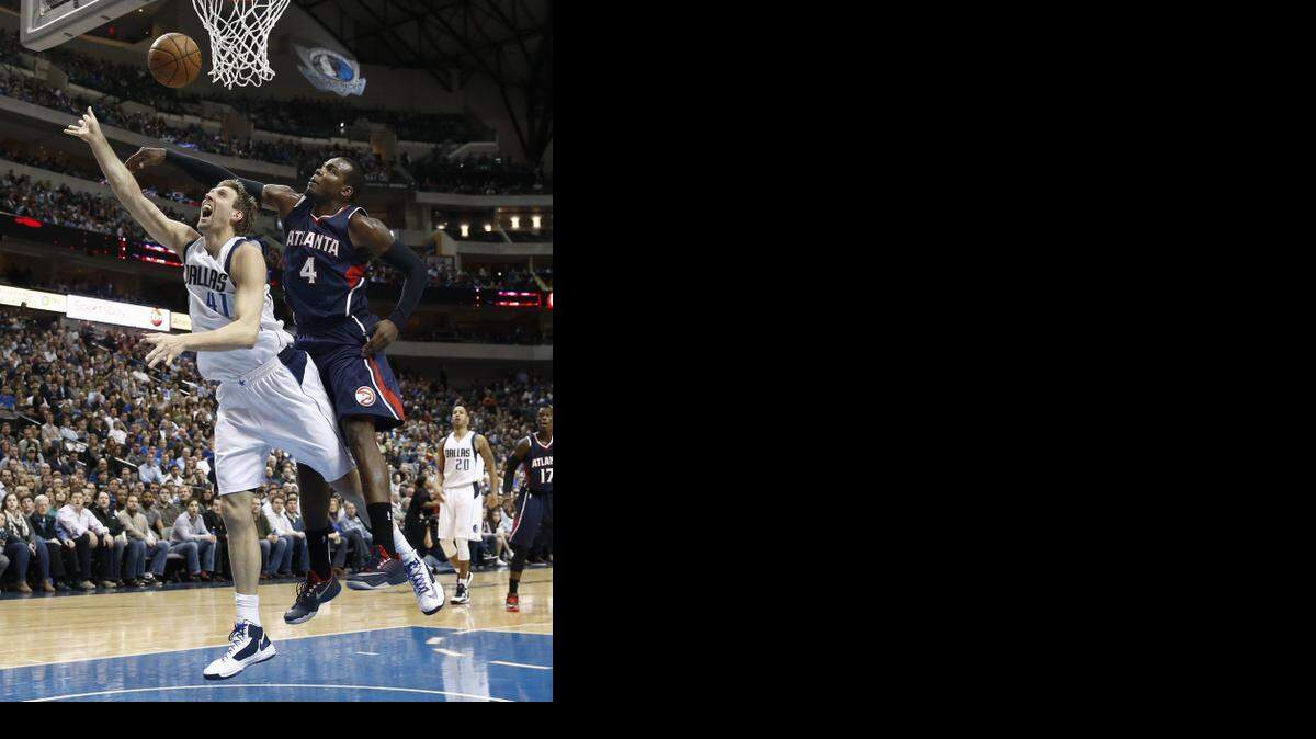 
 Hawks forward Paul Millsap  blocks a shot by  the Mavericks’  Dirk Nowitzki on Monday.


