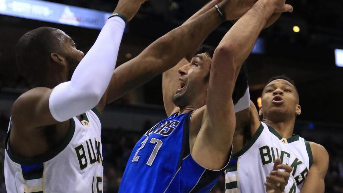 Dallas Mavericks center Zaza Pachulia, center, is defended by Milwaukee Bucks center Greg Monroe, left, and Giannis Antetokounmpo, right, during the first half of an NBA basketball game Friday, Jan. 8, 2016, in Milwaukee.