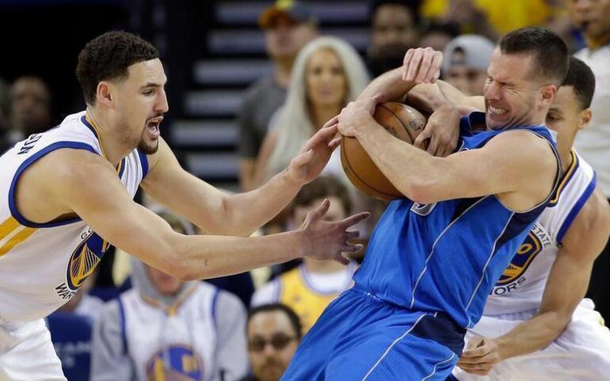 Dallas Mavericks guard J.J. Barea, middle, is pressured defensively by Golden State Warriors guards Klay Thompson, left, and Stephen Curry during the second half Friday. Golden State won 128-120.