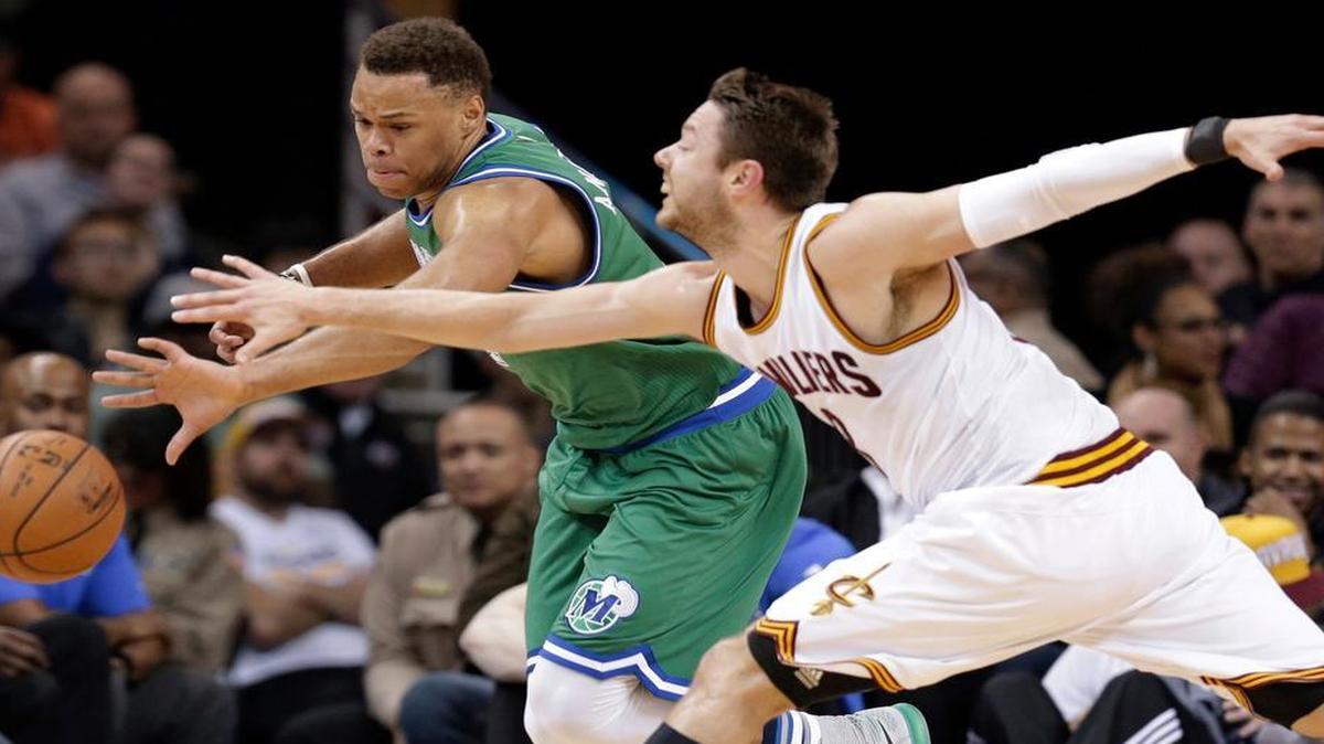 Dallas Mavericks’ Justin Anderson, left, and Cleveland Cavaliers’ Matthew Dellavedova, from Australia, battle for a loose ball in the first half of an NBA basketball game, Wednesday, March 16, 2016, in Cleveland.