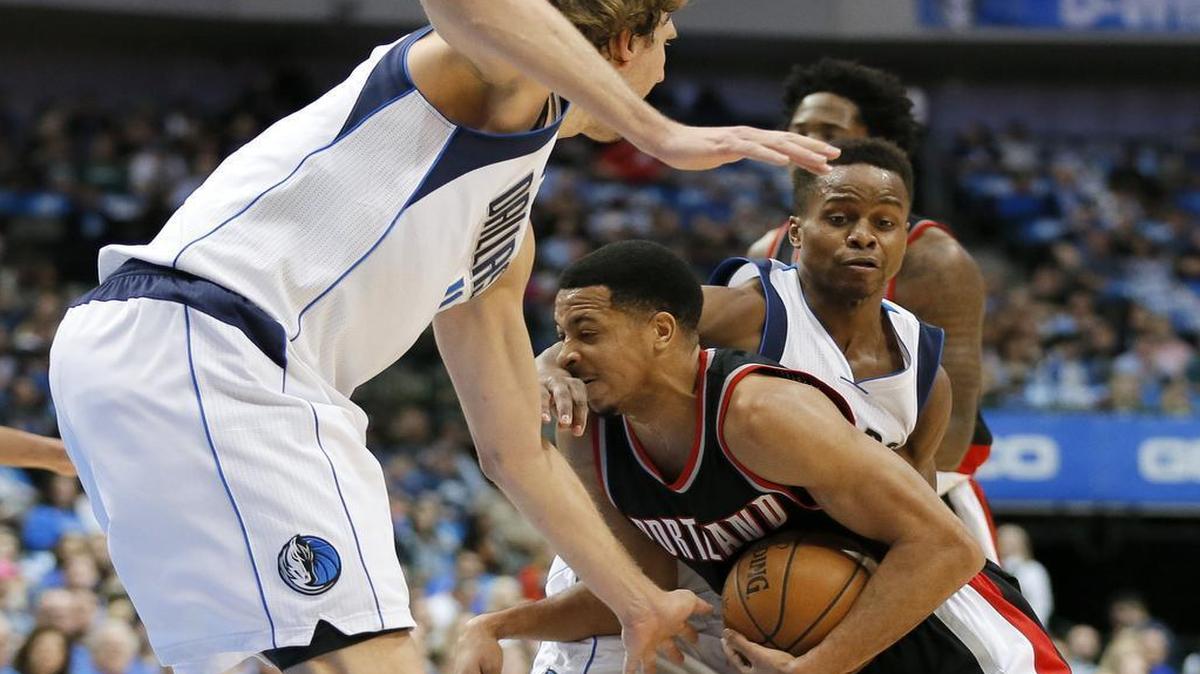 Portland’s C.J. McCollum fights between Mavericks Dirk Nowitzki, left, and Yogi Ferrell. McCollum scored the game-winning basket with 0.3 seconds to play.
