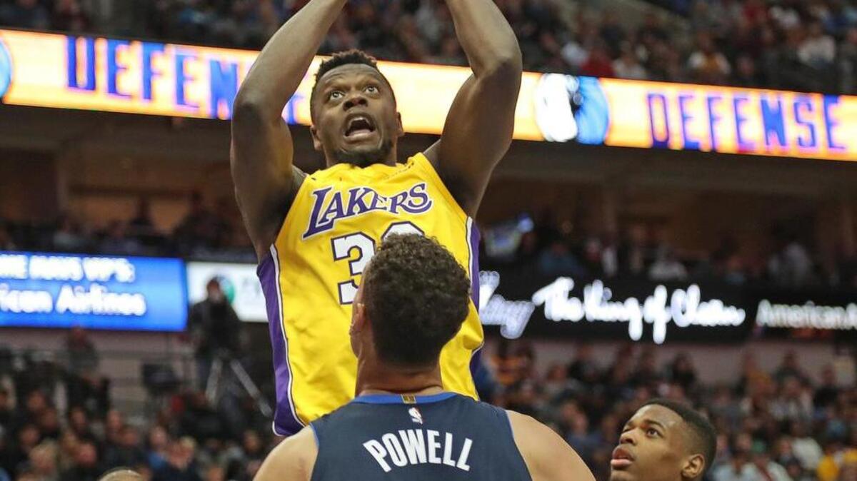 Forward Julius Randle (30), who led the Lakers with 23 points, rises above a trio of Mavericks defenders.