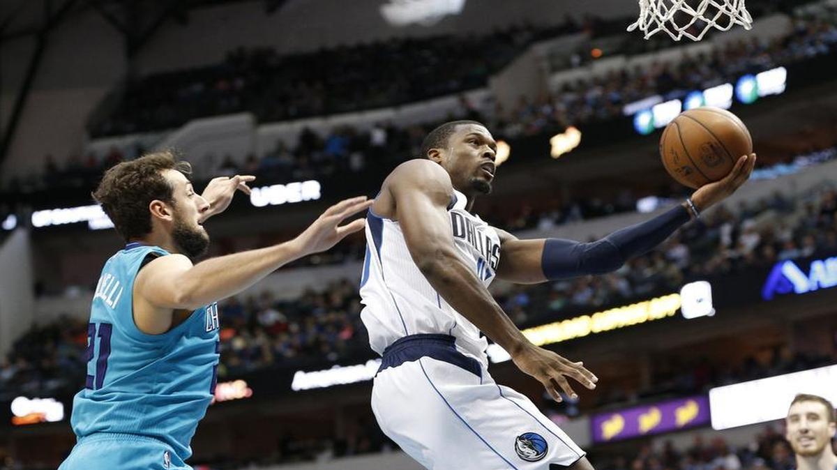 Harrison Barnes, right, led the Mavericks with 29 points, but Marco Belinelli and the Hornets rallied late for the victory Monday night.