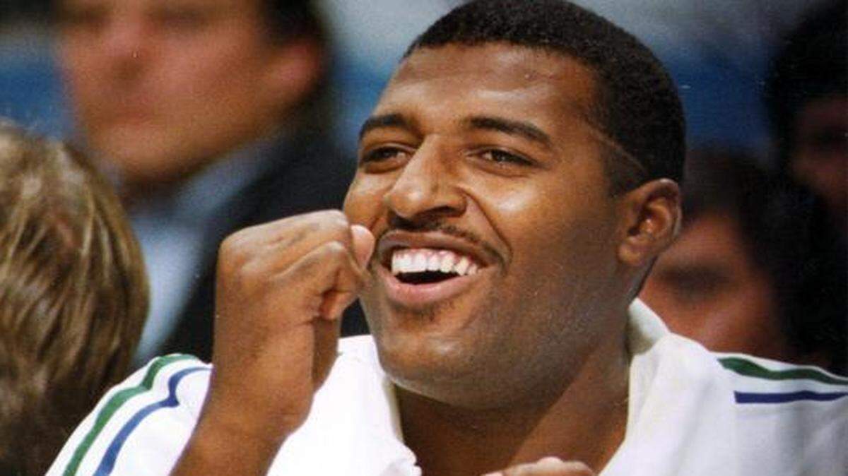 
Dallas Maverick Roy Tarpley pumps his fist and cheers from the bench. 
