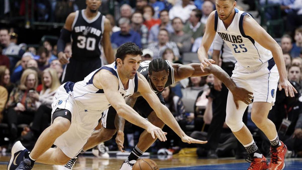 Mavericks center Zaza Pachulia and Spurs forward Kawhi Leonard dive for a loose ball in Friday’s blowout win by San Antonio.