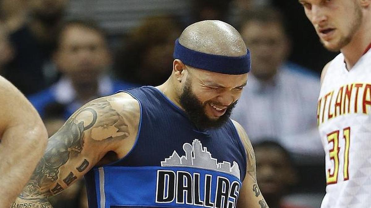 Mavericks point guard Deron Williams winces after suffering a bruised hip Monday against the Hawks.