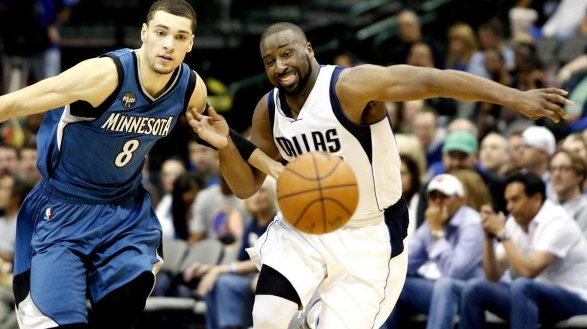 Raymond Felton, right, of the Mavericks and Zach LaVine of the Timberwolves chase a loose ball.