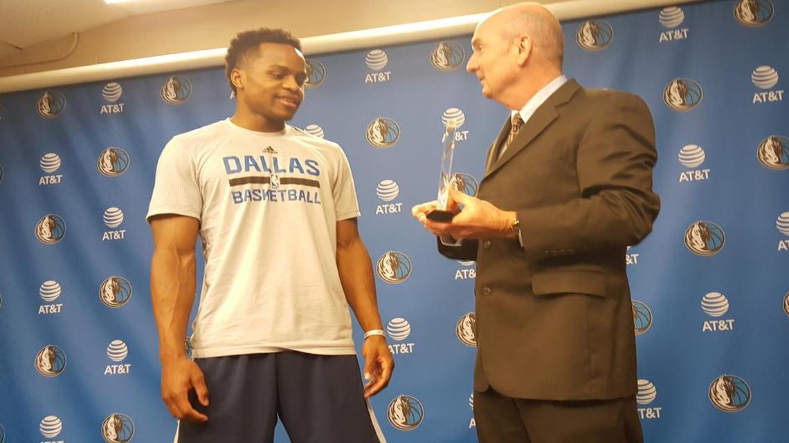 Mavericks guard Yogi Ferrell is presented his NBA rookie of the month award for February by Matthew Pfeifer, a district parts service manager for Kia.