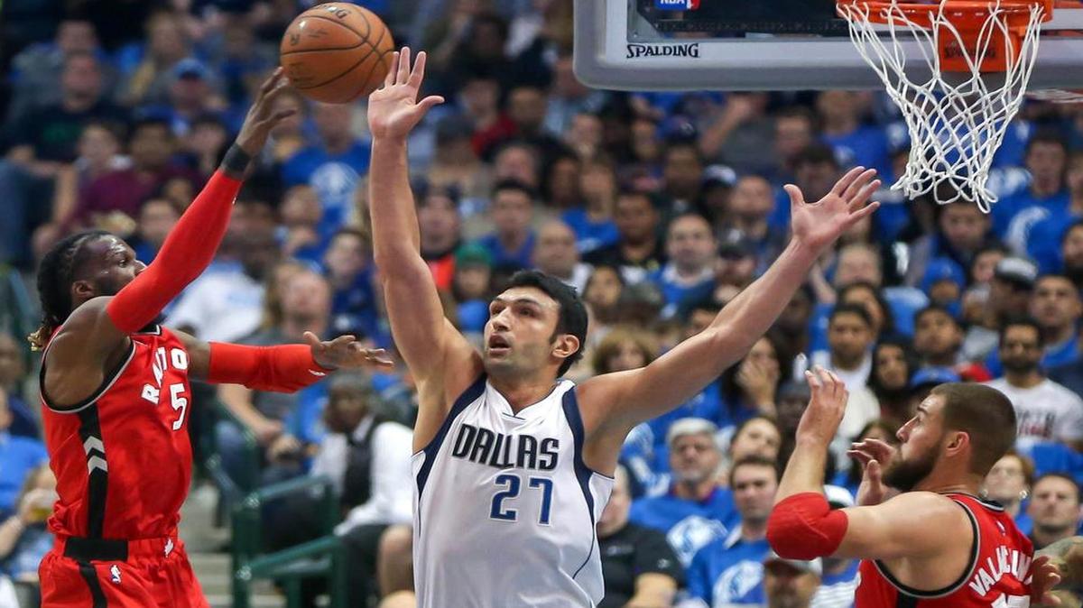 The Dallas Mavericks’ Zaza Pachulia (27) pressures a shot by the Toronto Raptors’ DeMarre Carroll (5) during the first quarter on Tuesday.