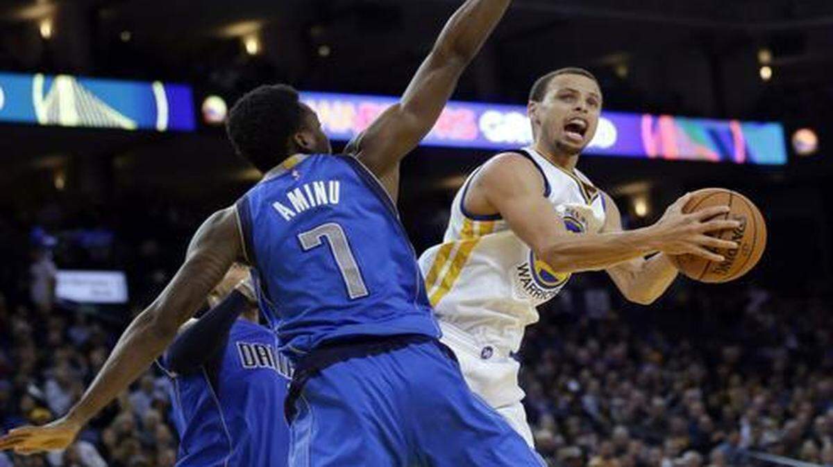 
Golden State Warriors guard Stephen Curry, right, goes around Al-Farouq Aminu of the Dallas Mavericks in Wednesday’s game in Oakland, Calif. Curry scored 26 points in the third quarter alone on his way to 51 points in a 128-114 win over Dallas.


