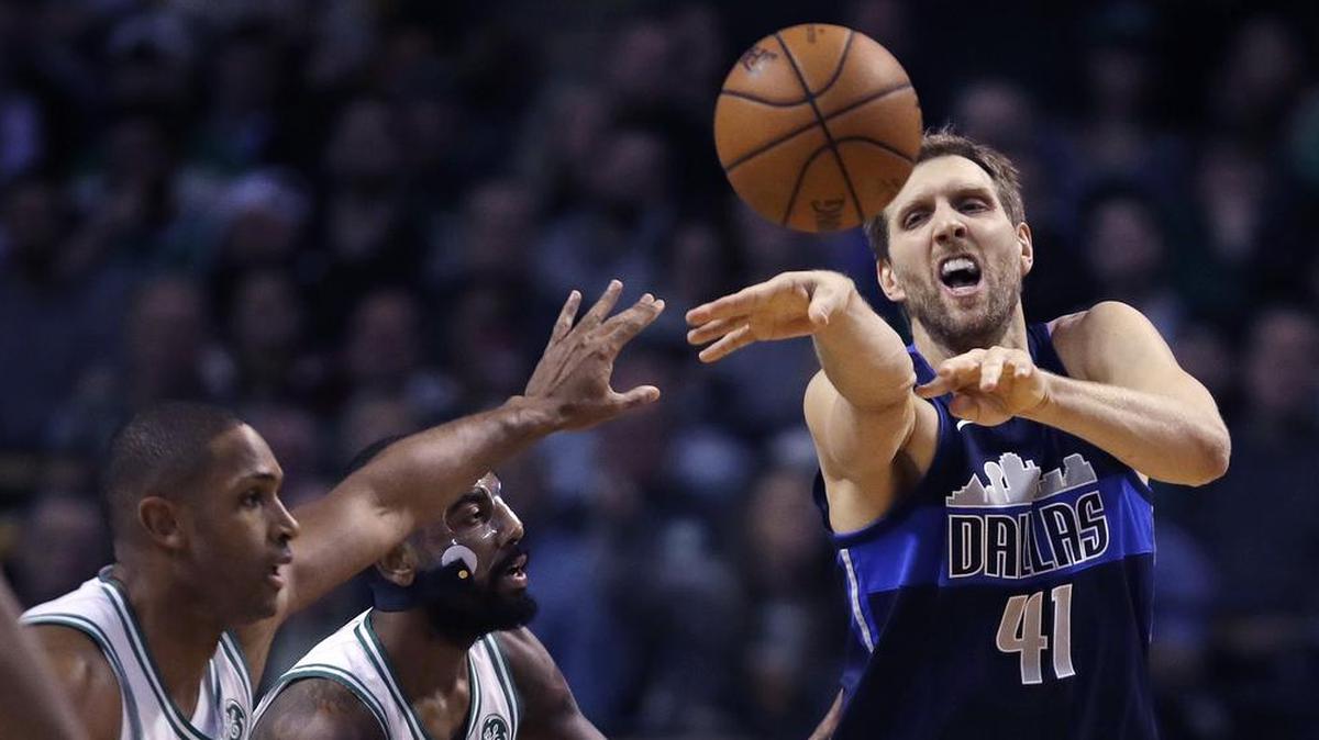 Dallas Mavericks forward Dirk Nowitzki (41) passes the ball while covered by Boston Celtics forward Al Horford, left, and guard Kyrie Irving during the first quarter of an NBA basketball game in Boston, Wednesday, Dec. 6, 2017.