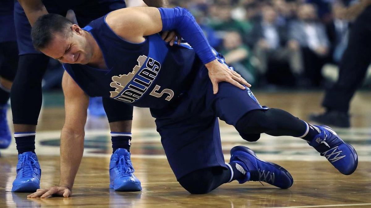 Mavericks guard J.J. Barea is helped off the court in the fourth quarter after straining his left calf. Coach Rick Carlisle said Barea will “be out for a while.”