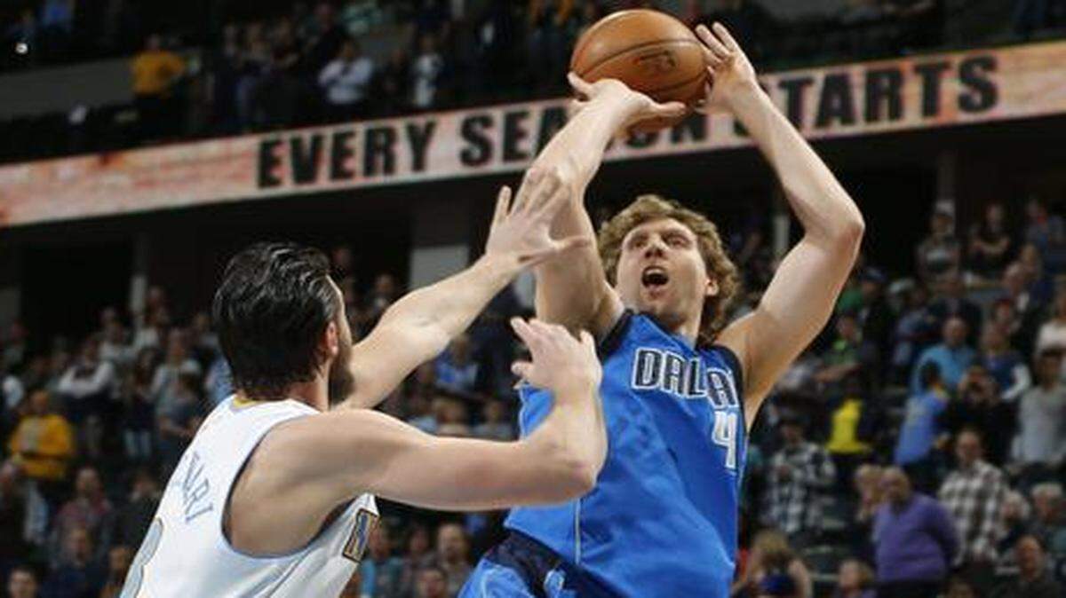 
 Mavericks forward Dirk Nowitzki, right,  shoots for a basket over  Nuggets forward Danilo Gallinari (in the first quarter Friday night. 
